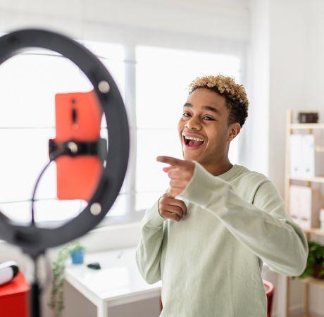 man smiling and looking at phone with light ring