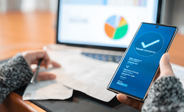 Woman at desk looking at phone