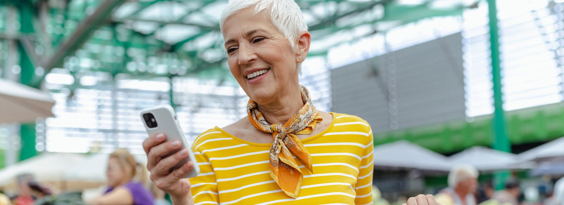 lady in yellow sweater looking at her cell phone